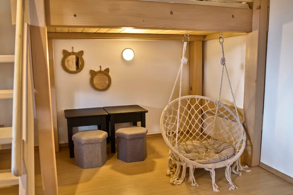 Hängesessel und kleine Sitzecke unter dem Hochbett