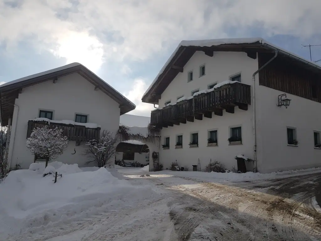 Weiße Hofgebäude mit Balkonen und Torbogen im Schnee
